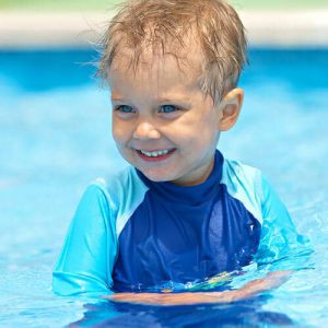 little boy smiling while in the pool