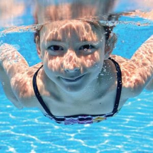 little girl smiling underwater