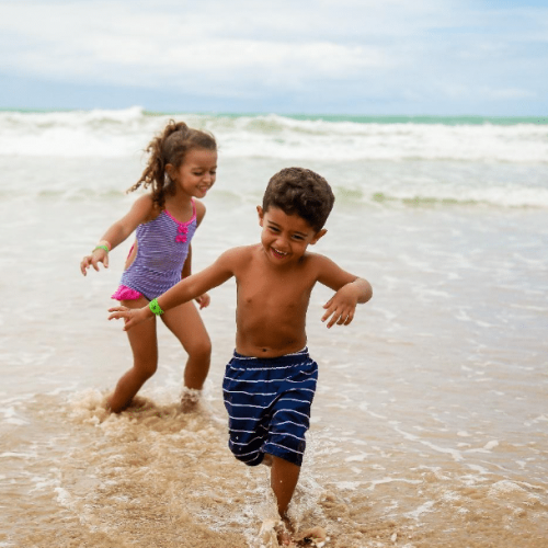 two children running at a beach