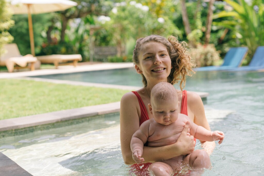 mother holding her baby in the pool