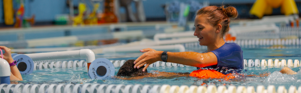 female swim coach teaching a child in the pool