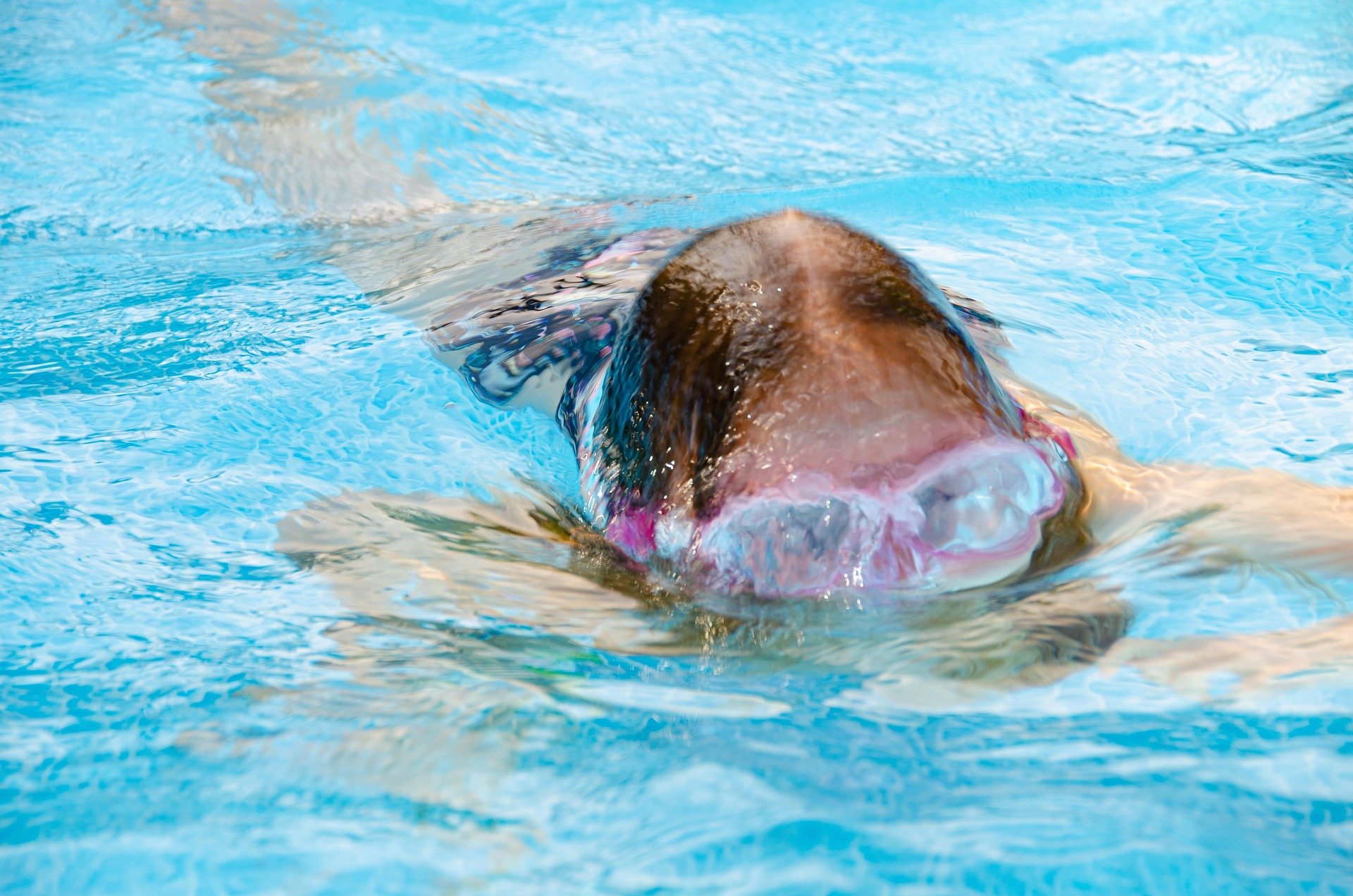 A young girl floating in the swimming pool
